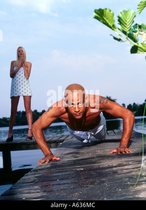 Junge Frau sucht jungen Mann Ausübung am pier Stockfoto