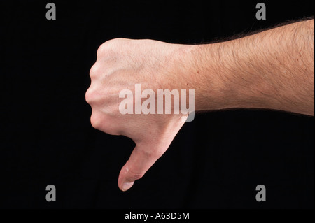 Menschliche Hand Daumen nach unten - nicht O.k. auf schwarzem Hintergrund Stockfoto