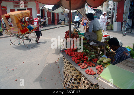 Pousse-Pousse vorbei an Litschi Ständen auf der Straße in Tamatave Toamasina Madagaskar Nein Herr Stockfoto