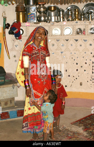 schöne indische, Banni tribal Frau und Kind in ihrer dekorierten Bhungas (tribal House) in der Nähe von Bhuj in Gujarat Stockfoto