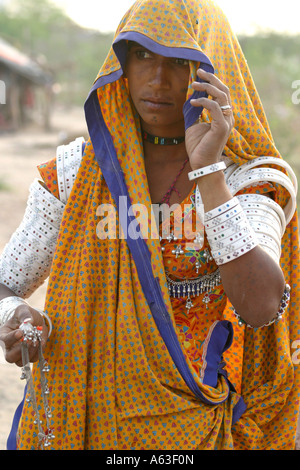 Fleißige MIR nomadischen Tribeswoman Gujarat, traditionellen Schmuck tragen und helle farbige Kleidung mit Schleier über dem Kopf Stockfoto