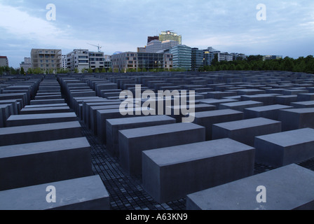 Beton-Stelen am Denkmal mit Gebäuden im Hintergrund, Holocaust-Mahnmal, Berlin, Deutschland Stockfoto