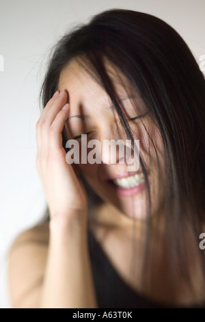 Asiatische Frau mit Kopfschmerzen Stockfoto