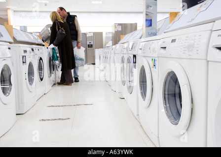 Paar, die sich neue Waschmaschinen in John Lewis, London, Großbritannien, angeschaut haben Stockfoto