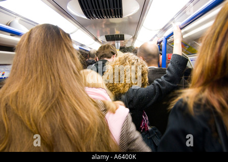 Personen reisen während der morgendlichen Berufsverkehr auf einer überfüllten U-Bahn Wagen arbeiten England UK Stockfoto