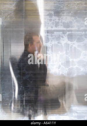 Abstrakte malerische Porträt des Menschen In seinem Büro durch getönten Milchglas Stockfoto