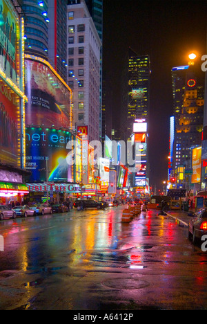 New York City Times Square bei Nacht im Regen mit hellen Lichtern und Reflexionen, New York, USA Stockfoto