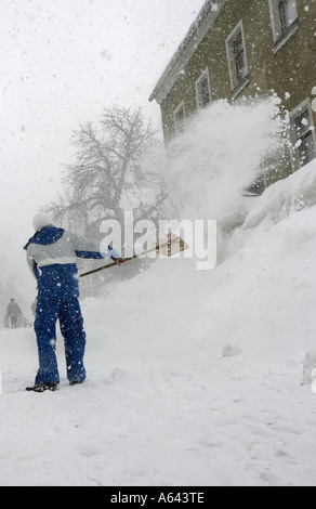 Mann nimmt Schnee von der Straße in Oberwiesenthal, Erzgebirge, Erz-Erzgebirge, Sachsen, Deutschland Stockfoto