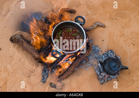 Abendessen und Tee kochen auf dem Feuer legen Sie in den Sand, Libyen Stockfoto