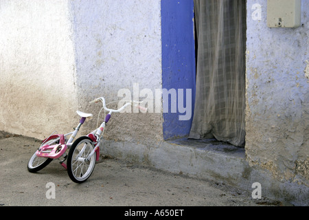 Des Kindes Fahrrad links außen eine Tür in Andalusien, Spanien Stockfoto