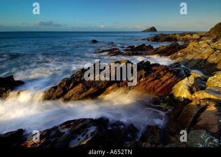 Schöne Dämmerung Licht bei wembury Strand mit dem Meer wirbeln um die freiliegende Felsen und die mew Stein am Horizont Stockfoto