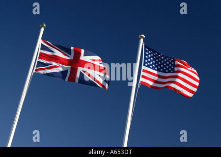 Union Jack und Stars And Stripes Flaggen von Großbritannien und den USA fliegen neben gegen blauen Himmel Stockfoto