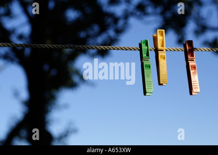 Drei bunte Wäscheklammern auf einer Linie. Stockfoto