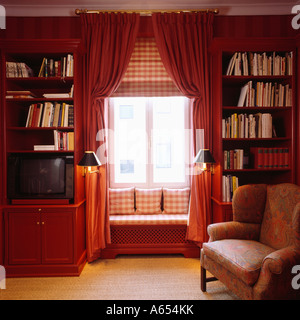 Fensterplatz mit Check Kissen und passende Blind im Gartenhaus mit Regalen auf beiden Seiten des Fensters Stockfoto