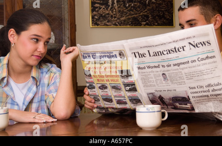 Kaukasischen Mann 20 bis 23 ignoriert Frau beim Lesen der Zeitung USA Stockfoto