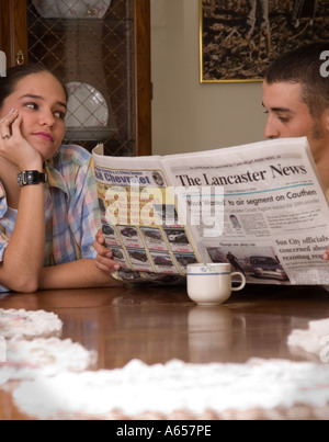 Kaukasischen Mann 20 bis 23 ignoriert Frau beim Lesen der Zeitung USA Stockfoto