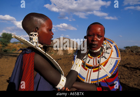 Massai-Frauen malen ihre Gesichter mit rotem Ocker in Vorbereitung einer Zeremonie Longido, Tansania Stockfoto