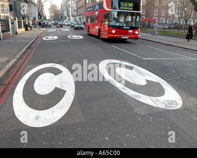 London Congestion Charging hat gerade begonnen 17/02/03 zwei weiße C-Logos auf der Straße warnen vor Ladebereich doppelt rote Route keine Haltestellen Euston England UK Stockfoto