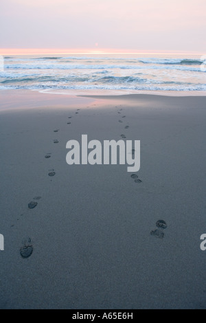 Schuhabdrücke am Pazifischen Ozean sandigen Strand bei Sonnenuntergang Stockfoto