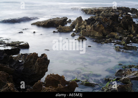 gezackte Küstenfelsen und Wellen fotografiert mit Langzeitbelichtung beschlagen Effekt erstellen Stockfoto