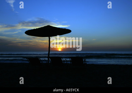 Silhouette von Liegestühlen mit Sonnenschirm am Strand, Sidi Kaouki, Essaouira, Marokko Stockfoto