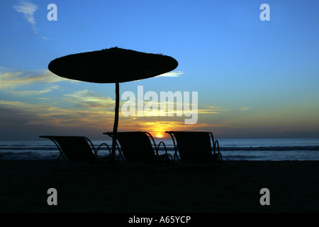 Silhouette von Liegestühlen mit Sonnenschirm am Strand, Sidi Kaouki, Essaouira, Marokko Stockfoto