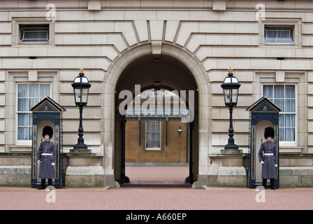 Wachposten der Queens Guard im Winter Uniform stationiert auf dem Vorplatz des Buckingham Palace London England Stockfoto