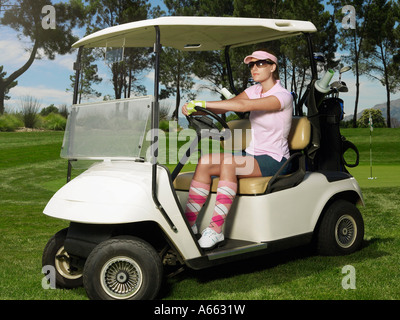 Junge weibliche Golfer in Sitze in Warenkorb Stockfoto