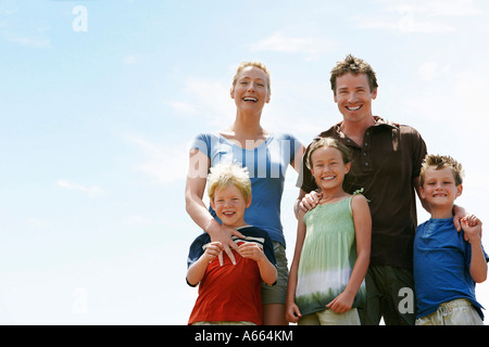 Drei Kinder (7-9) mit den Eltern im Freien, niedrigen Winkel Porträt. Stockfoto