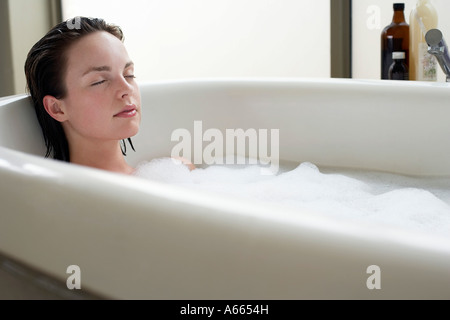 Junge Frau Entspannung im Sprudelbad, Augen geschlossen Stockfoto