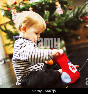 Ein kleines Kind auf der Suche in einem Weihnachts-Strumpf Stockfoto