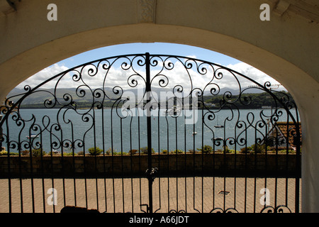 Ein Blick auf das Festland und Bangor Pier durch ein schmiedeeisernes Tor von Beaumaris, Anglesey Stockfoto