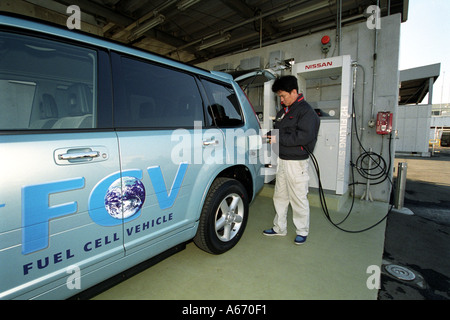 Ein Nissan-Arbeiter lädt ein Nissan Fuel Cell Vehicle Elektroauto in einer Ladestation Anlage im Nissan-Werk in Japan Stockfoto