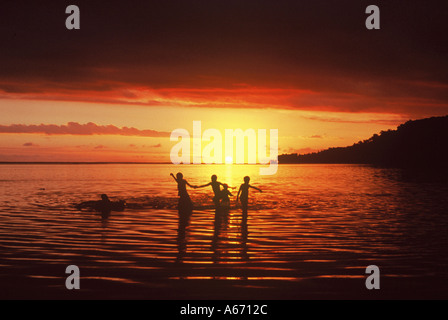 Kinder spielen im Meer bei Sonnenuntergang, Fidschi-Inseln Viti Levu Coral Coast Stockfoto