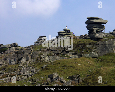 Person, die am blauen Himmel der Cheesewring Stones auf der Ostflanke des Bodmin Moor bei Stowes Hill Linkinhorne Minions Cornwall England UK steht Stockfoto