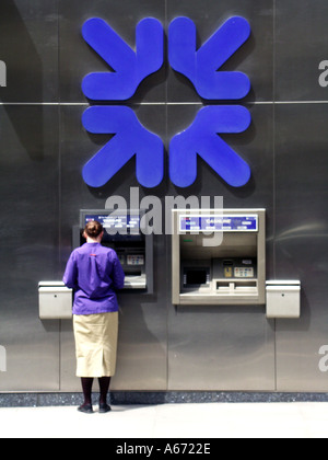 Royal Bank of Scotland großes blaues Firmenlogo an der Wand Rückansicht Frau mit Geldautomat-Loch in der Wand Kassenspender-Pflaster in City of London England Großbritannien Stockfoto