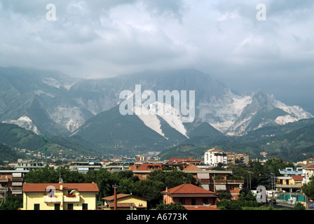 Wohngebiete unter einen Sommer Blick auf die weissen Steinbruch arbeiten in die Apuanischen Alpen, die berühmten Carrara Marmor für Skulptur & Gebäude Toskana Italien Stockfoto
