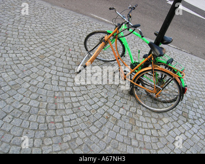 2 einzelne Fahrräder gesperrt, Laternenpfahl Stockfoto