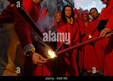 Falleras in Rot kostüm Beleuchtung Fackeln am Anfang des Cavalcada del foc Feuer Parade während Las Falles Festival in Valencia, Spanien Stockfoto