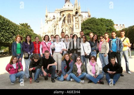 Schulgruppe der kaukasischen Teenager posiert für die Kamera vor Notre Dame Paris Frankreich Stockfoto