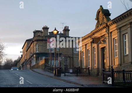 Shipley College Mühlengebäude und Eingang zum Bahnhof station Saltaire Bradford mit morgendlichen Sonnenlicht fangen das Mauerwerk Stockfoto