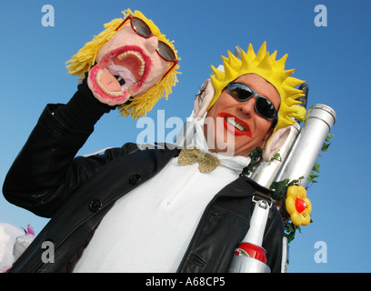 Mann verkleidet ein Gesicht Maske blauen Himmel hochhalten Stockfoto