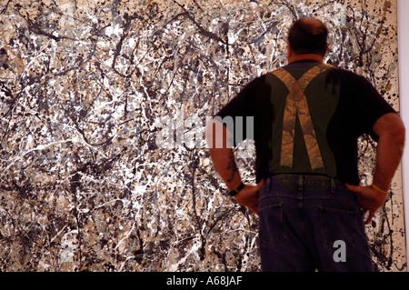 Mann mit passenden Klammern stand vor Jackson Pollock Malerei an der kürzlich neu eröffneten Museum für moderne Kunst in new Yor Stockfoto