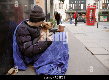 Junge Obdachlose Person mit seinem Haustier Hund betteln im Zentrum von London. Stockfoto