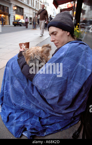 Junge Obdachlose Person mit seinem Haustier Hund betteln im Zentrum von London. Stockfoto