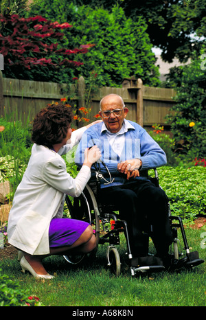 Home health care Krankenschwester besucht mit einem älteren männlichen Patienten in seinem Garten Stockfoto