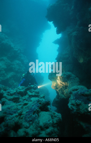 Scuba Diver wirft ein Licht auf Felsformation Stockfoto
