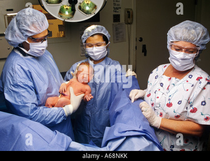 Arzt und Krankenschwester in einem Krankenhaus Kreißsaal mit ein neugeborenes Kind Stockfoto