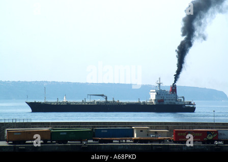 Seitenansicht Frachtschiff, das schwarzen Rauch und Rußemissionen vom Trichter aufstoßen, der die lokale Atmosphäre und Umwelt verschmutzt, Ankunft im Hafen von Palma Mallorca Spanien Stockfoto