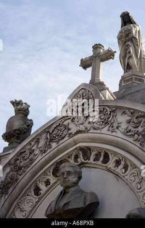 Büste, Statuen und Kreuz oben auf einem Grab in Recoleta Friedhof Stockfoto